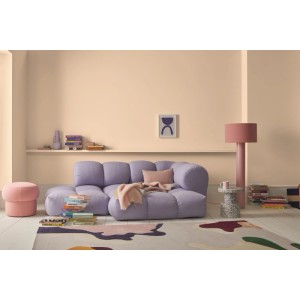 Alpina Innenfarbe Pantone Brazilian Sand an Wänden im Wohnzimmer. Sandbeige matte Wandfarbe mit lila Sofa.
