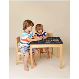 Bambini che dipingono un tavolo con vernice lavagna nera. Design creativo con colori a gesso.