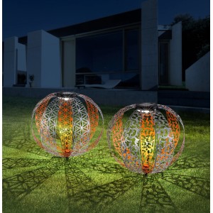 Due luci solari a sfera Globo argentate Ø 30cm con ornamenti in giardino.