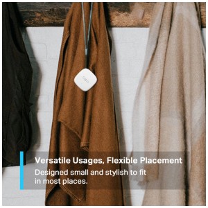 Thermo-hygromètre blanc Tapo T310 avec cordon suspendu à un porte-manteau. Mesure précise de la température et de l'humidité.