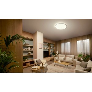 Plafonnier LED Philips Valen rond blanc en plastique, éclaire un salon moderne.