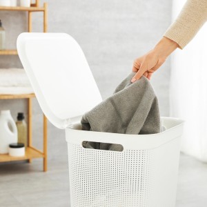 Cesto portabiancheria Rotho Brisen bianco (50 l) con coperchio, pieno di bucato.
