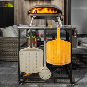 Pelle à pizza Ooni et ustensiles de grill sur un chariot pour four à pizza.