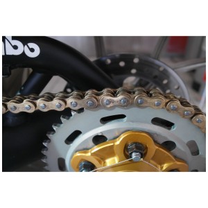 Gros plan d'une chaîne de moto graissée sur le pignon. Idéal pour l'entretien avec le spray pour chaîne Dr. Wack S100 Dry Lube.