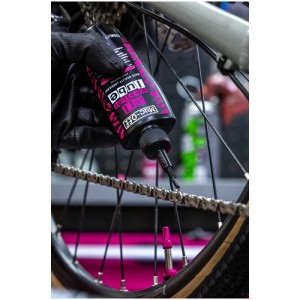 Olio catena Muc-Off All Weather Lube applicato su una catena di bicicletta.