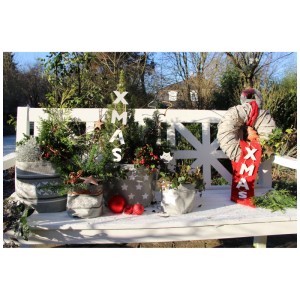 Cache-pots en jute avec motif norvégien et plantes sur un banc dans la neige.