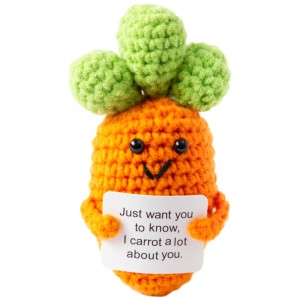 Gehäkelter Glücksbringer Positive Carrot, orange, mit lächelndem Gesicht, hält Schild mit Spruch.