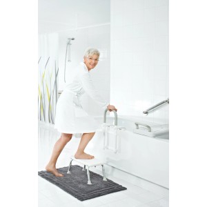 Femme utilisant l'aide à l'entrée de baignoire Ridder (6-13cm) en blanc pour une entrée sécurisée.