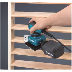 Ponceuse vibrante Makita BO4565 ponçant du bois, avec aspiration de poussière.