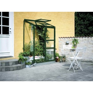 Serre Halls Altan 2, serre adossée verte avec plantes contre le mur de la maison.