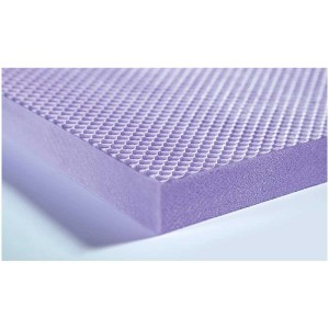 Gros plan d'un panneau isolant en mousse rigide XPS violet avec une surface texturée.