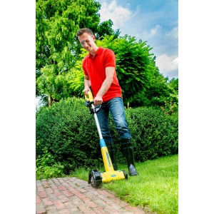 Uomo utilizza Gloria tagliabordi Cut&Brush 2-in-1 per la cura dei bordi del prato in giardino.
