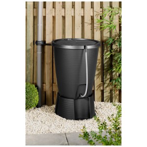 Serbatoio acqua piovana Keter Indigo nero 220 l con base, su ghiaia e sfondo verde.