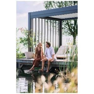 Pergola Biohort grigio scuro/argento (4x3m) con coppia vicino all'acqua. Copertura per terrazza per feste in giardino.