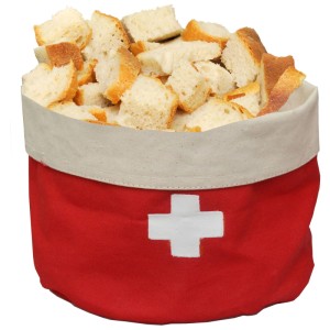 Runder Brotkorb von Heidi Cheese Line mit Schweizer Kreuz, rot-weiß, gefüllt mit Brot.