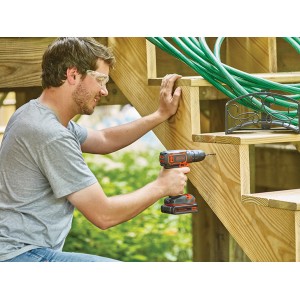 Homme perçant un escalier en bois avec une perceuse-visseuse sans fil Black+Decker BDCDC18. Batterie incluse.