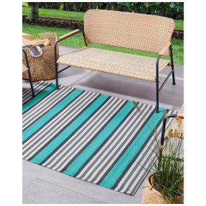 Beliani Outdoor-Teppich Saugor, rechteckig, türkis-grau gestreift, 120x180 cm, auf Terrasse vor Gartenbank.