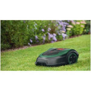 Robot tondeuse Bosch Indego S+ 500 4G sur pelouse devant des arbustes en fleurs.
