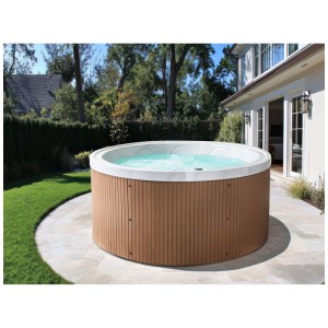 Spa extérieur rond Beliani Marfil avec revêtement aspect bois marron sur une terrasse claire dans un jardin.