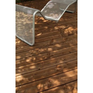 Lames de terrasse en pin rainuré couleur teck comme planches de terrasse avec chaise longue dans le jardin.