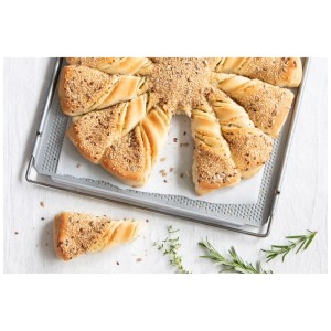 Silbernes Herdbackblech mit gelochtem Boden, darauf knuspriges Brot mit Saaten. Perfekt für Backofen & Küchenhelfer.