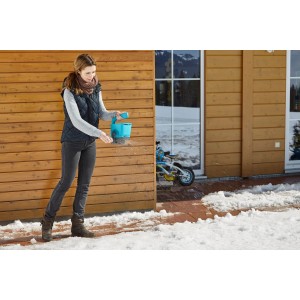 Donna sparge sale su superficie ghiacciata con spargitore manuale Gardena M.