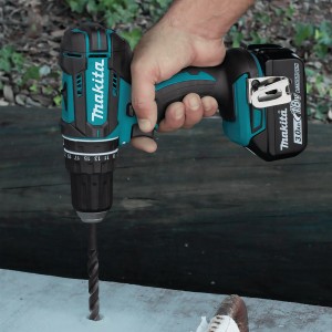 Trapano avvitatore a percussione a batteria Makita 18V in uso durante la foratura.