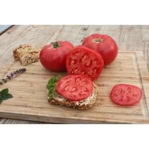 Pomodoro rosa Blu Tomate Rose Crush su tagliere di legno, frutto intero e affettato.