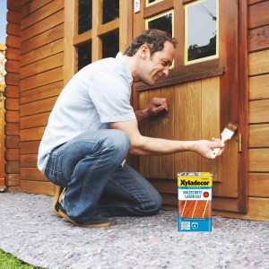 Homme appliquant lasure bois Xyladecor palissandre. Lasure bois 2en1 pour extérieur.