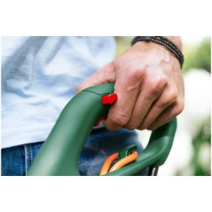 Coupe-bordures Bosch EasyGrassCut 23 en utilisation, main sur la poignée avec interrupteur rouge.