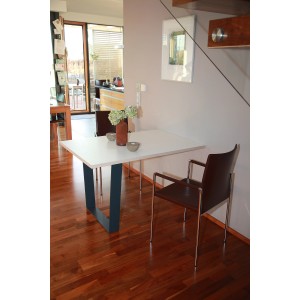 Piètement de table noir en forme de V (700x710mm) sous un plateau blanc dans un salon.