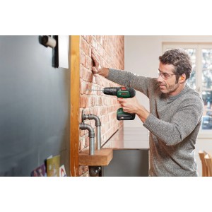Uomo che fora muro di mattoni con avvitatore a batteria Bosch UniversalImpact 18V.