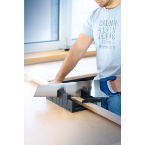 Homme sciant du bois avec une boîte à onglets LUX 300 mm et une scie à main. Réglages d'angle fixables.