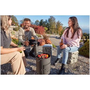 Globe de feu et de grill Olympia Ø 80 cm avec des grillades et trois personnes dans le jardin.