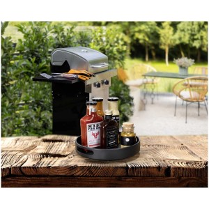 Drehbares Wenko Tablett Susie (Ø 26cm) mit Saucen auf einem Holztisch, Grill im Hintergrund.