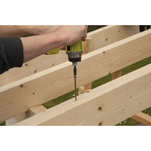 Artigiano avvita punta Wolfcraft Impact in trave di legno con avvitatore a batteria.