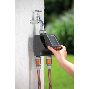 Programmateur d'arrosage Gardena MultiControl duo sur robinet avec deux tuyaux connectés.