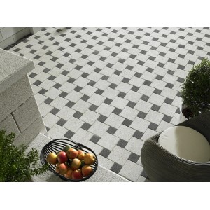 Pavés carrés blancs (hydrogommés) 20x20x6 cm posés avec des accents sombres dans le jardin.