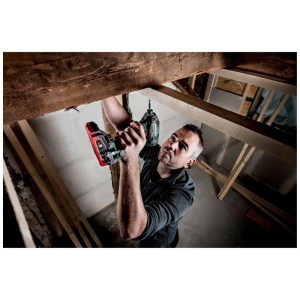 Uomo avvita con avvitatore a impulsi a batteria Metabo SSD 18 LTX 200 BL in una trave di legno.