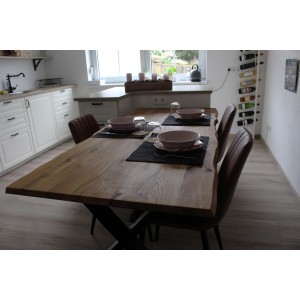 Piano tavolo in legno massello di rovere selvatico con bordo albero, oliato, tavola apparecchiata in cucina.