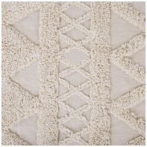 Gros plan : Tapis beige à poils courts Didim avec motif géométrique et franges.