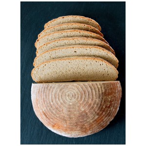 Brotlaib angeschnitten, gebacken im runden Gärkorb aus Naturmaterialien.