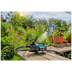 Gardena Pompe de jardin 3700/4 Basic en utilisation : femme arrosant le jardin. Pompe électrique avec accessoires.