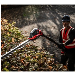 Taille-haie télescopique sans fil Einhell GP-HH 18/50 Li T BL-Solo en cours d'utilisation pour tailler une haie.