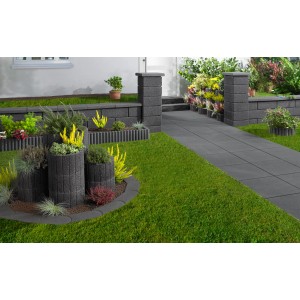 Muro da giardino antracite con copertine e bordure abbinate in un giardino paesaggistico.