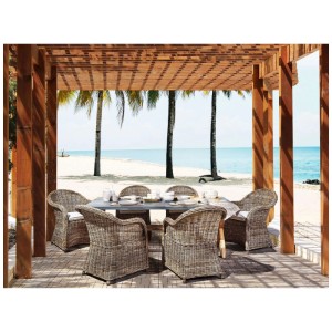 Ensemble de meubles de jardin Beliani Susua/Olbia: table en fibrociment, 6 chaises en rotin avec coussins sous pergola sur plage.