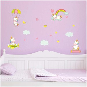 Stickers muraux Baby Unicorns taille L sur un mur de chambre d'enfant au-dessus d'un lit.