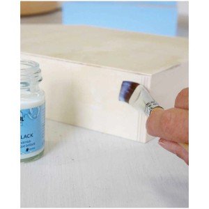 Auftragen von mattem Acryllack (Kreul) auf eine Holzkiste mit einem Pinsel. Bastelfarbe für DIY-Projekte.