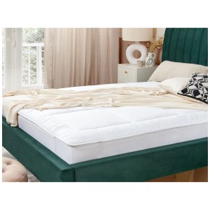 Surmatelas blanc Yangra 160x200 cm sur un lit avec une tête de lit verte.