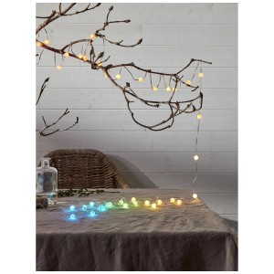 Guirlande lumineuse LED Star Trading Smart Fairy Light Multicolor avec 66 LED sur une branche et sur une table.